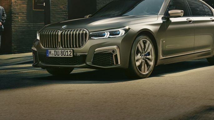 BMW M760Li xDrive in urban setting BMW M760Li xDrive in lateral front view driving on street in urban setting