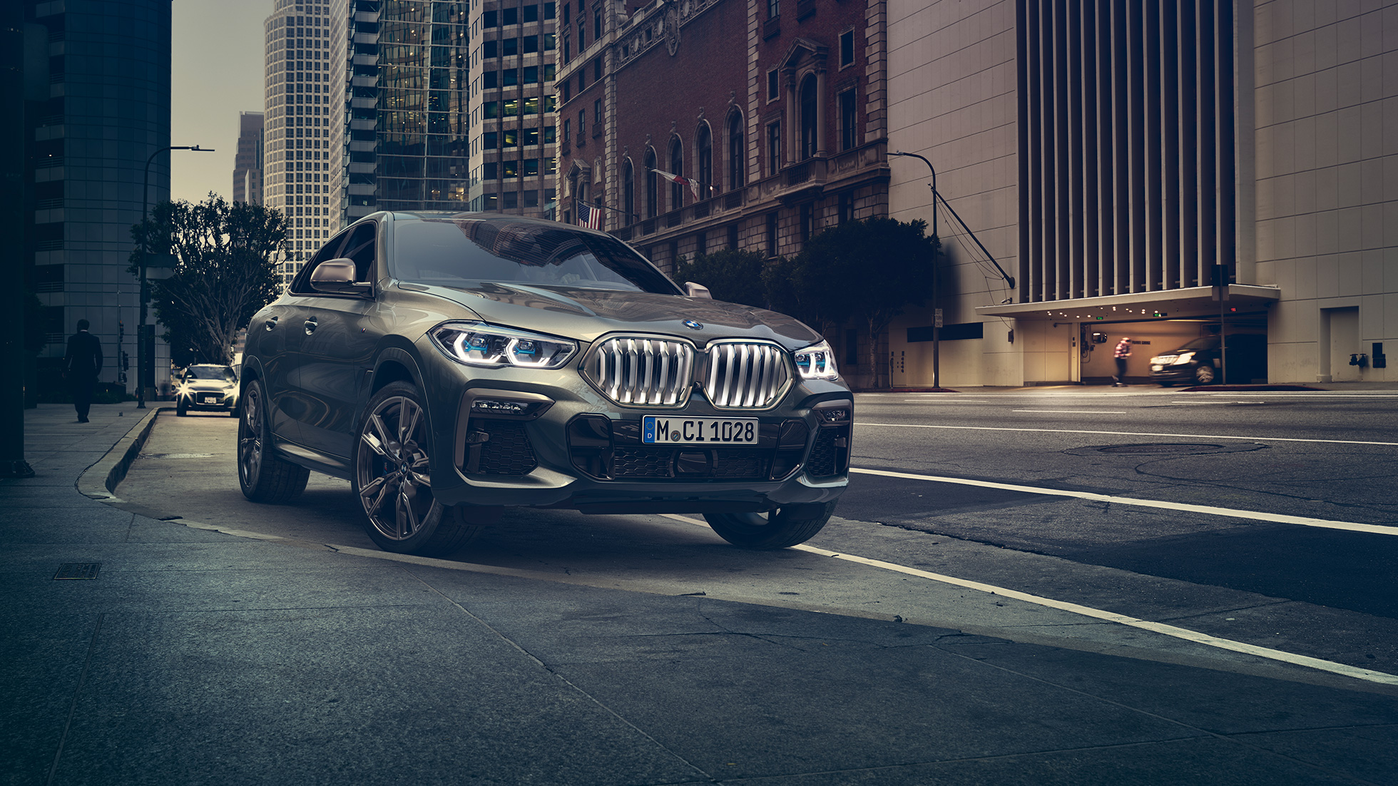 BMW X6 M50i standing BMW X6 M50i in three-quarter front perspective standing in front of an urban setting