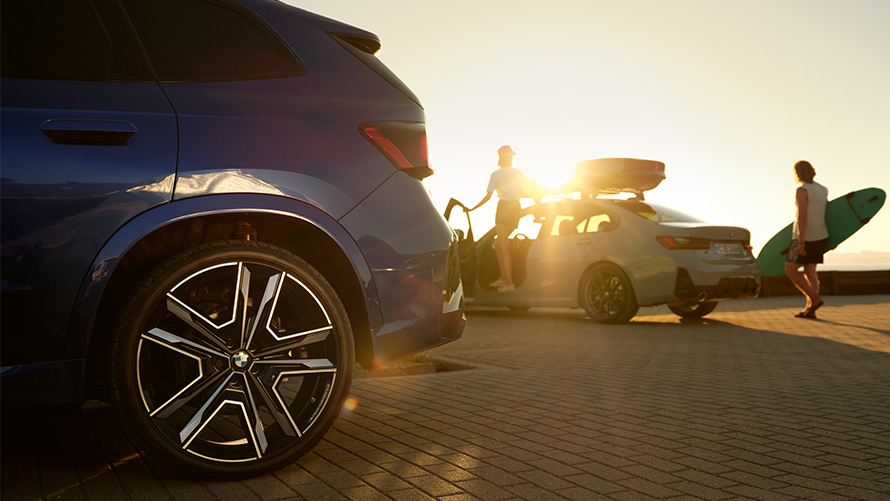 BMW Wheels and Tyre Service BMW Wheels and Tyre Service BMW X1 U11 with two people on BMW vehicle in background with sun